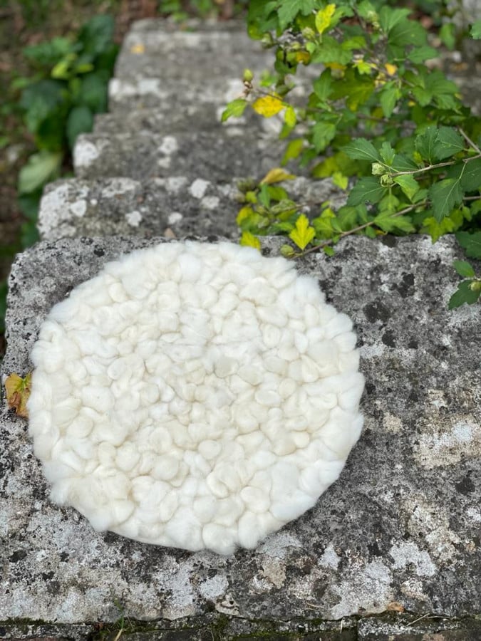 Handmade round cushion with sheep knots