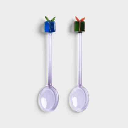 2 small spoons with gift on top of them
