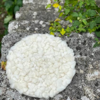 Handmade round cushion with sheep knots